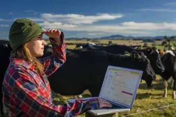 NZ_Female with laptop and cattle – Active Tag software